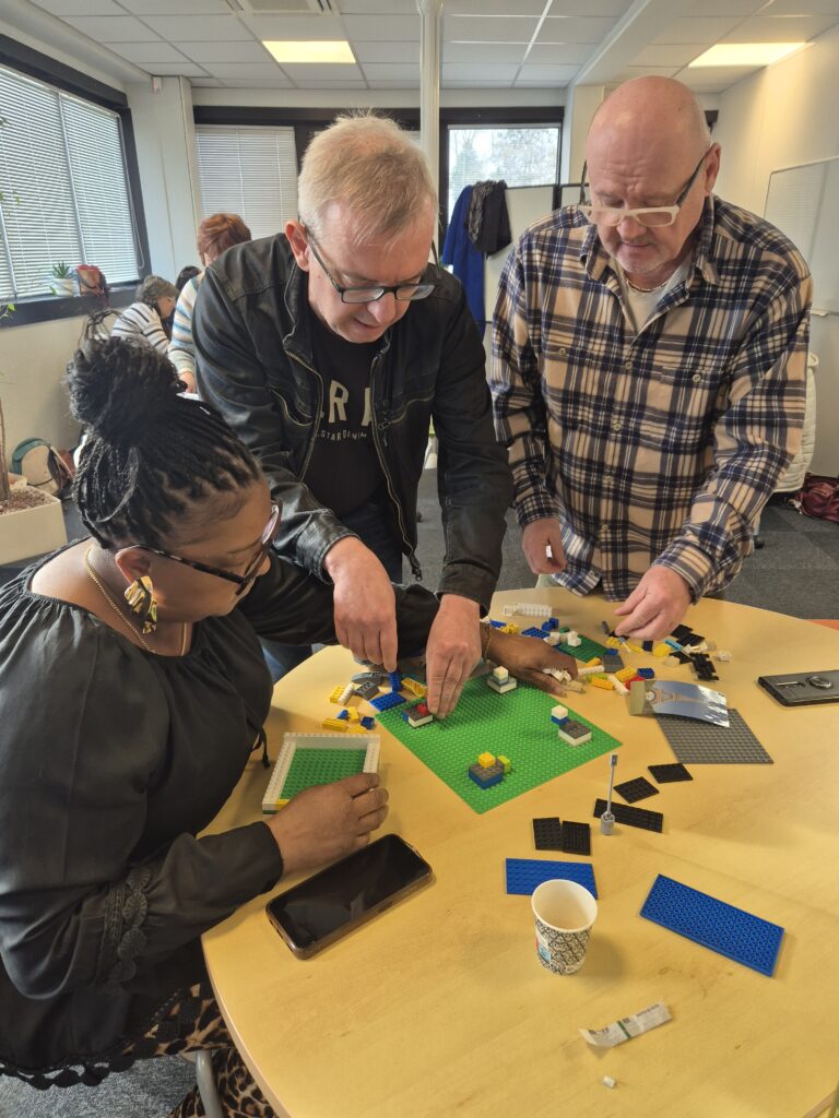 Groupe de participants en activité créative autour de logos favorisant le travail d’équipe et la communication.