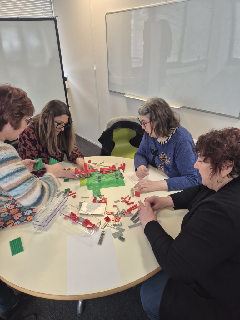 Atelier collaboratif : participants créant et échangeant autour de logos pour développer la communication et l’esprit d’équipe.